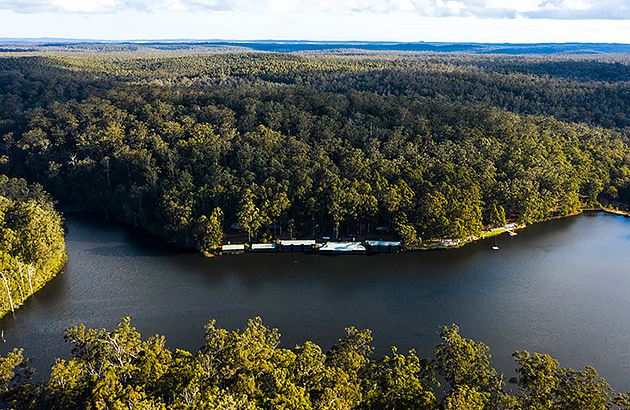 An aerial photo of forest and RAC Karri Valley Resort on the lake in Pemberton