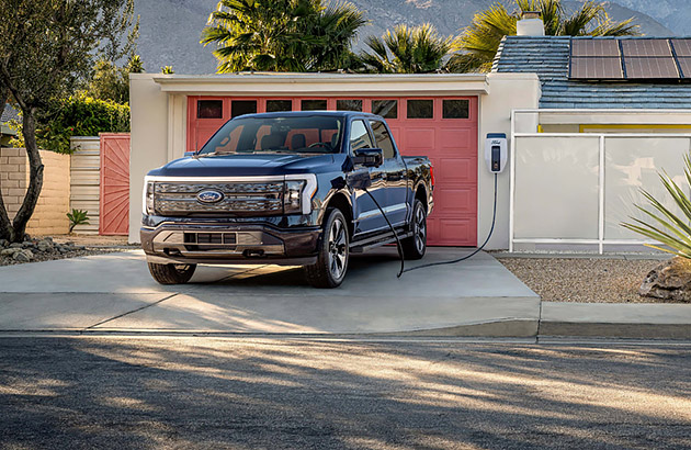 A black Ford F150 in the driveway of a home