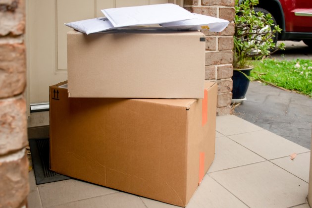 Pile of deliveries in large cardboard boxes at front door