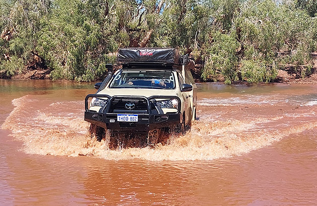 A four-wheel drive crossing a river