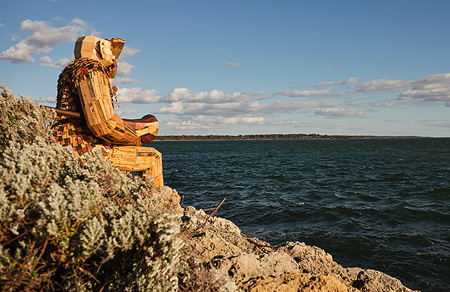 One of Thomas Dambo's wooden Giant sculptures looking out over water