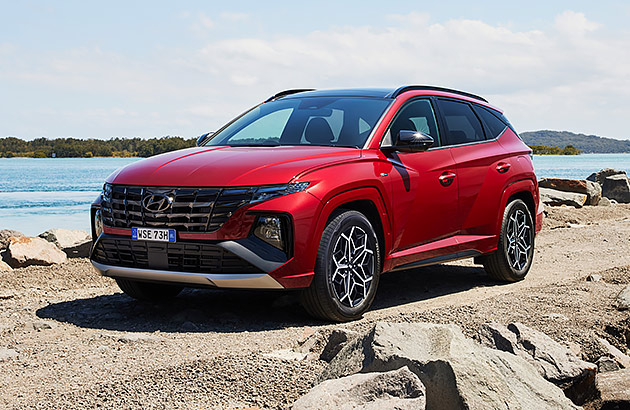 A red Hyundai Tucson parked near a lake