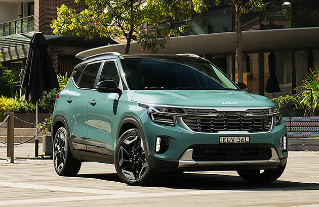 A green Kia Seltos on a city street