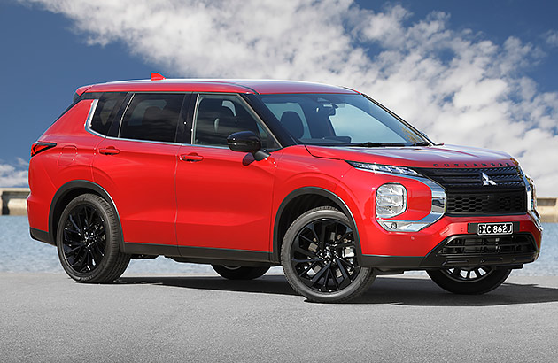 A red Mitsubishi Outlander in a coastal carpark