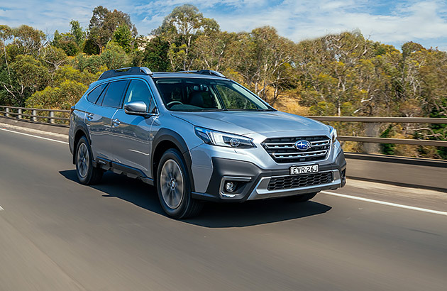 Silver Subaru Outback driving on a country road