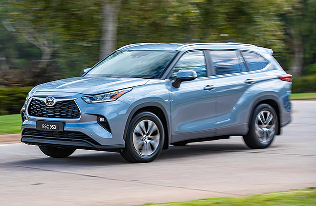 A silver-blue Toyota Kluger driving on a suburban road