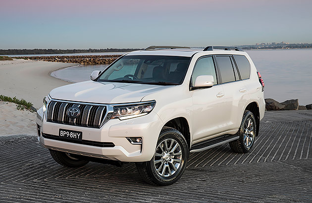 A white Toyota Prado parked on a boat ramp