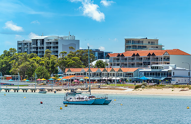  A beach viewed from the water with a jetty and a boat near it