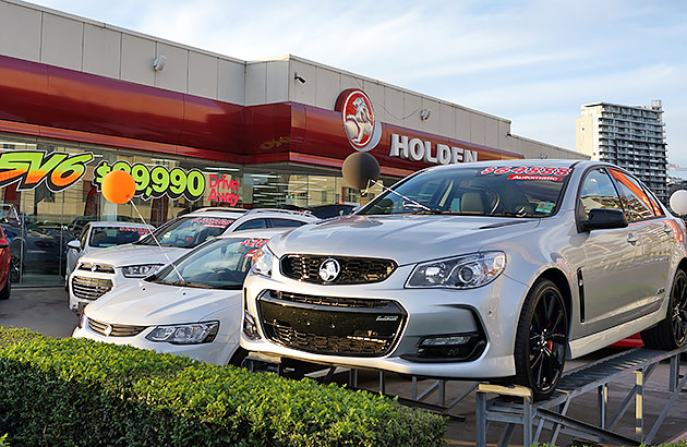 A row of cars for sale outside a car dealership