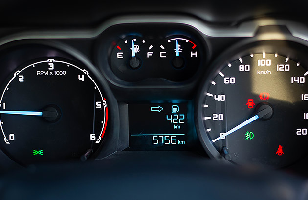 Close up of a car dashboard showing a speedometer