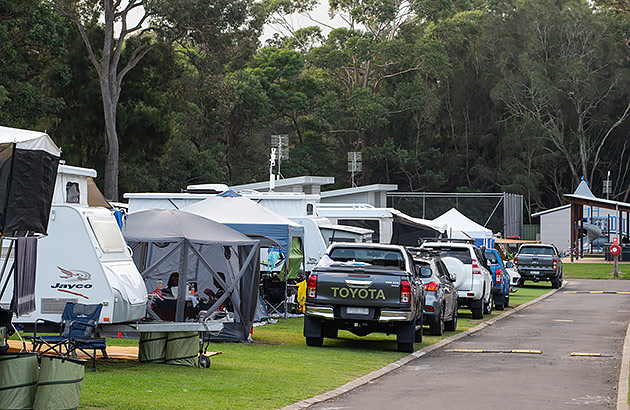 A row of tents and caravans in a busy caravan park