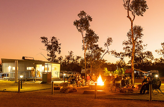  People sitting around a campfire at dusk at Djarindjin campground