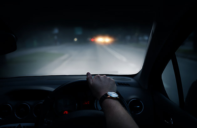 From a car interior a driver is approaching another car in the distance