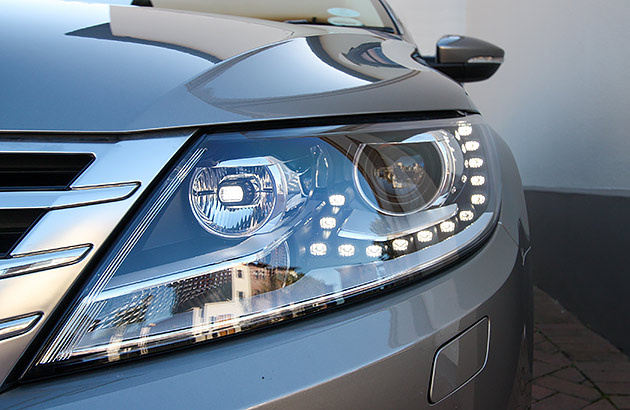 A close-up of a car with daytime running lights on