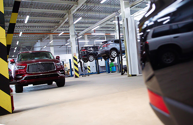 A car servicing workshop with cars up on hoists