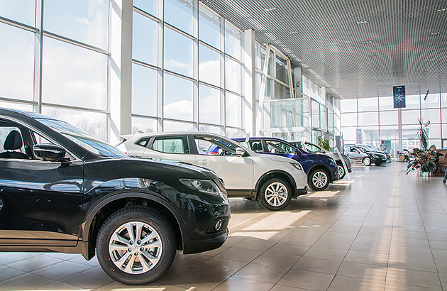 A car showroom with a line of cars that are for sale