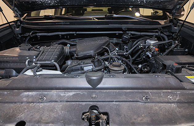 A car bonnet raised to show an older car engine