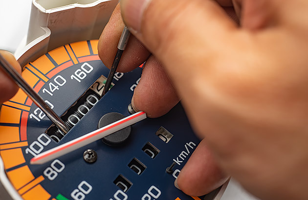 A close up of someone winding back a car speedometer