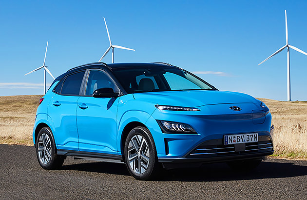 A bright blue Hyundai Kona EV on a country road