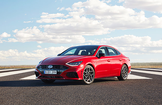 A red Hyundai Sonata on a country  road