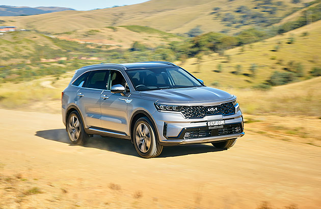 A silver Kia Sorento on a dry dirt track