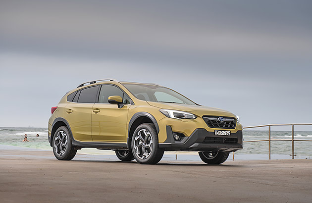 A gold Subaru XV parked near a beach