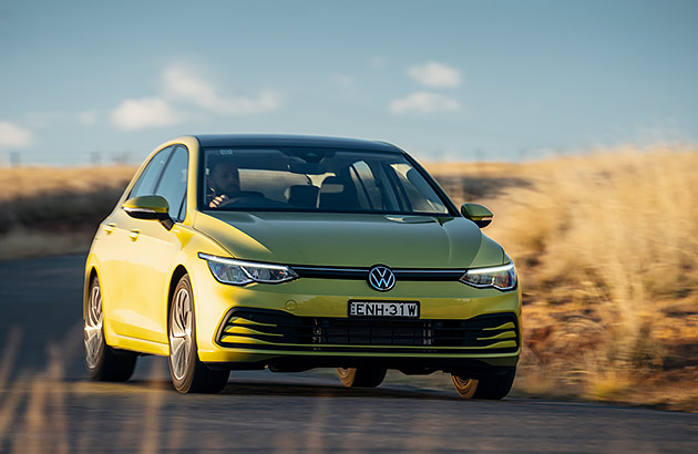 A green VW Golf on a country road