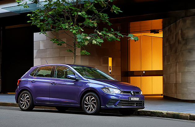 A purple VW polo parked on a city street