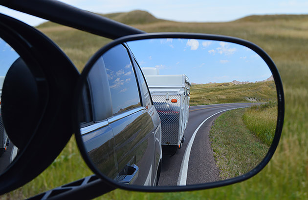 A tow mirror on a car with a caravan reflected