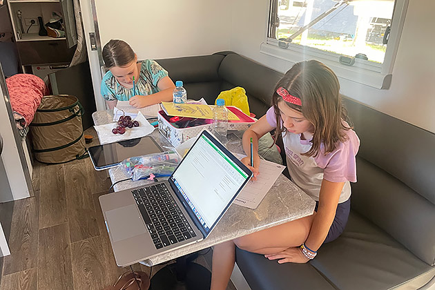 Two Morrell girls doing home school in the family caravan