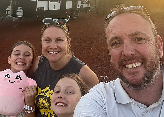 The Morrell family standing in front of their caravan