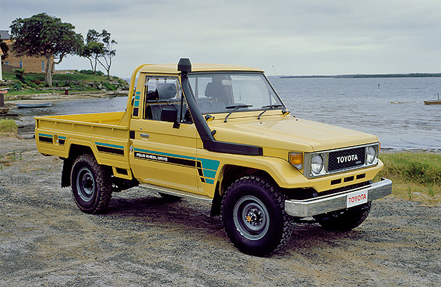 A yellow 1984 Toyota LandCruiser on a beach