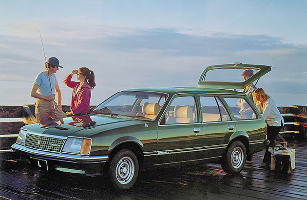 Two couples near a green Holden Commodore station wagon