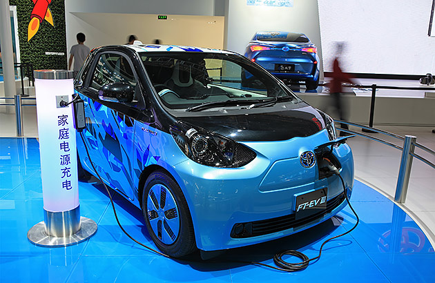 A small blue Toyota brand electric car being charged