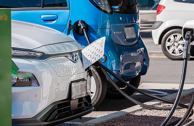 Two EVs charging at a public EV charging station