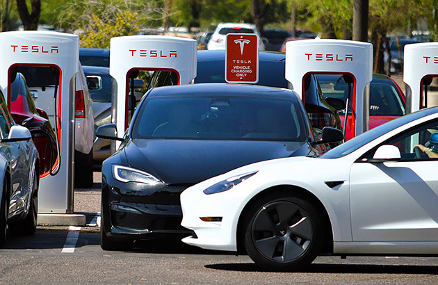A Tesla EV charging station with one car waiting to charge