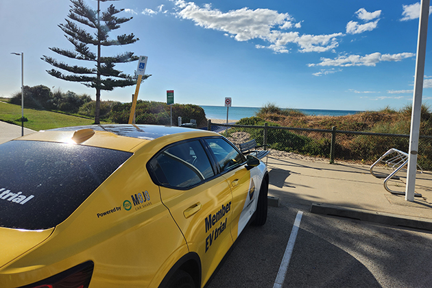 A Polestar 2 EV parked in a car park by the beach