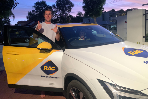 Man doing thumbs up in front of Polestar 2 electric car