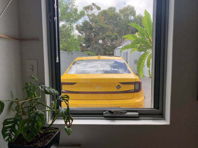 View from window of yellow Polestar 2 electric vehicle parked in driveway