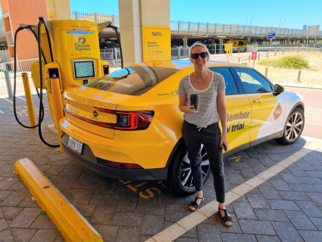 Woman standing in front of RAC branded Polestar 2 electric car at electric charging station