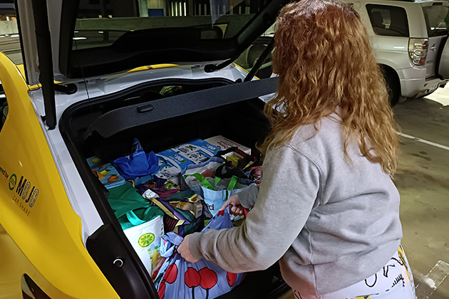 A woman loading shopping in the boot of a car