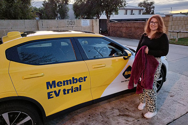 A woman posing with a Polestar 2 EV