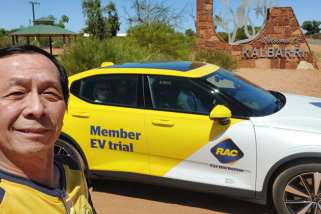 A man posing for a selfie with an electric vehicle