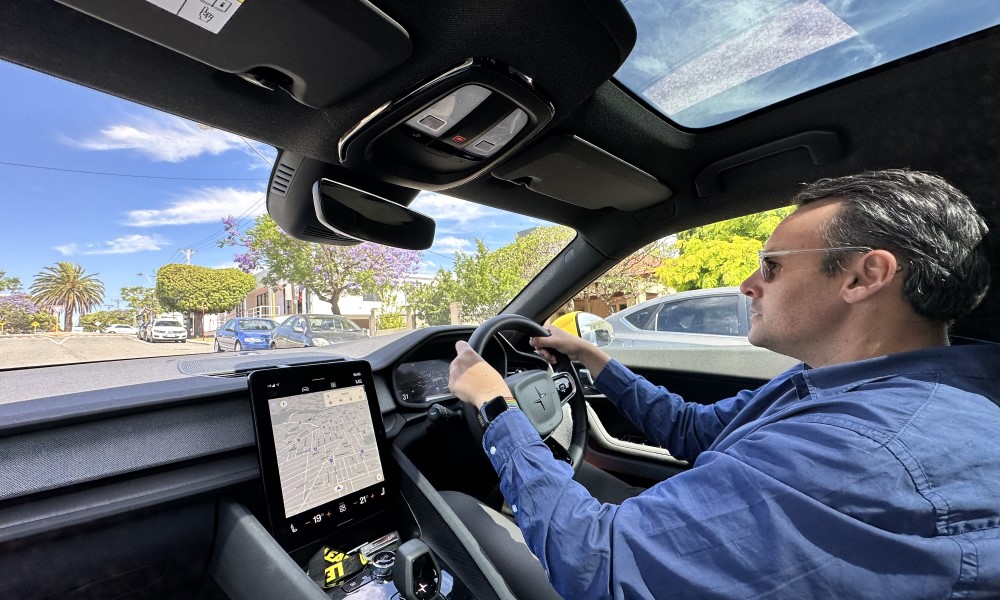 Photo of interior of Polestar 2 electric car with man in blue shirt at the wheel