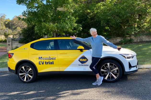 RAC member standing in front of Polestar 2 electric car on street with trees in background