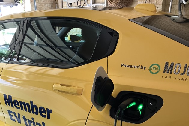 Close up of Polestar 2 electric car with yellow RAC branding charging in a home garage