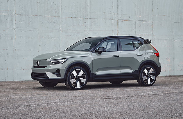 A grey Volvo XC 40 Recharge parked next to a grey wall