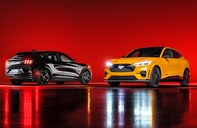 Two Ford Mustang Mach Es in a studio setting lit with red light