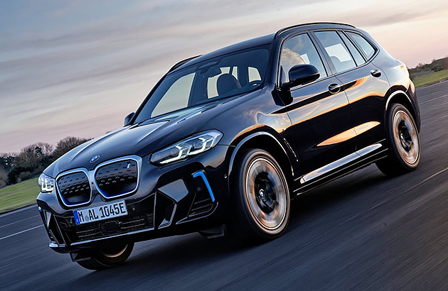 A black BMW iX3 on a country road