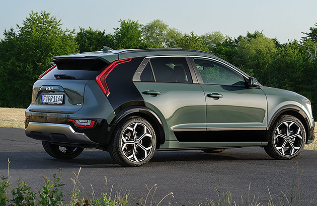 A green Kia Niro II EV parked on a country road